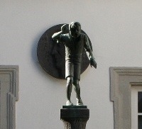 Die Bronzefigur des Schängels vor einer Hauswand